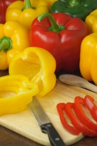 Foto: Gelbe und rote Paprika auf einem Schneidebrett mit Messer