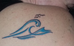 Foto: Tattoo einer Welle mit Möwen auf der Schulter