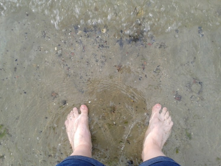 Foto: Mit den Füßen im Wasser stehend