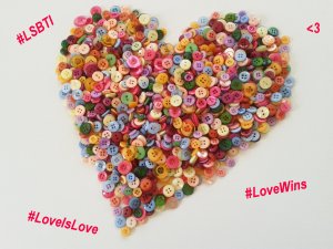Foto: Bunte Knöpfe zu einem Herz gelegt, mit den Hashtags #LSBTI, #LoveIsLove und #LoveWins