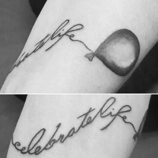 Foto: Tattoo am Handgelenk mit Schriftzug "Celebrate life" der als Schnur in einen Luftballon übergeht