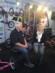 Foto: Nadine sitzt auf der REHACARE 2017 mit einem Mikrofon in der Hand neben ihrem Interviewpartner Bob